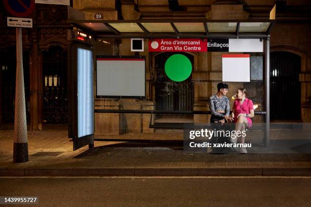 バルセロナで夜にバスを待つ若者たち - bus shelter ストックフォトと画像