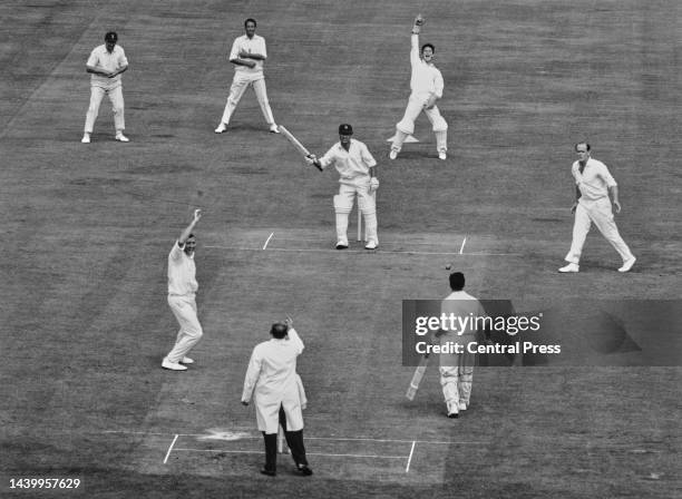 England wicketkeeper Alan Knott and bowler Geoff Arnold raise their arms to appeal as umpire Syd Buller signals the dismissal of opening batsman...