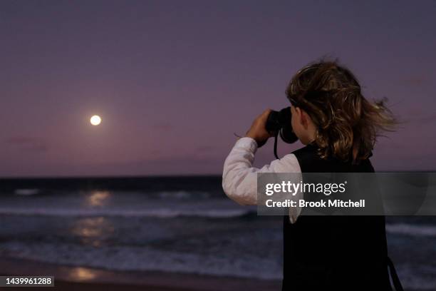 Young boy looks out to the moon on Manly beach as a partial eclipse of the Moon begins on November 08, 2022 in Sydney, Australia. Australians will...