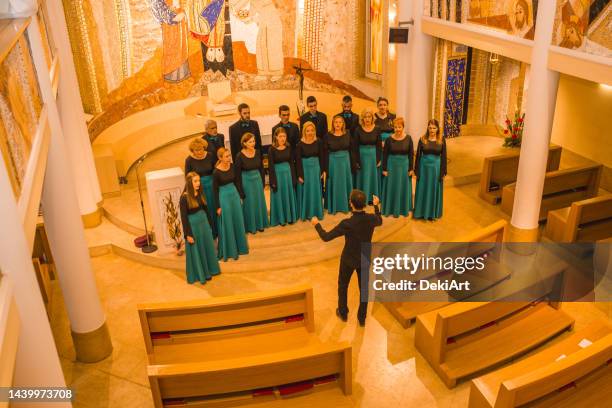 der dirigent übt mit dem chor vor dem konzert in der kirche - klassische orchestermusik stock-fotos und bilder