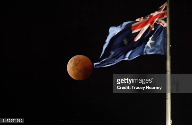The full "Blood Moon" lunar eclipse rises over the Australian Parliament House on November 08, 2022 in Canberra, Australia. Australians will...