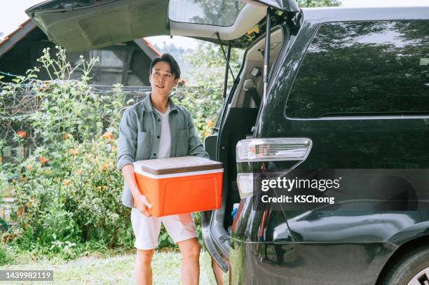 asiatischer junger mann bereitet sich auf die reise im sommer vor - ice bucket stock-fotos und bilder