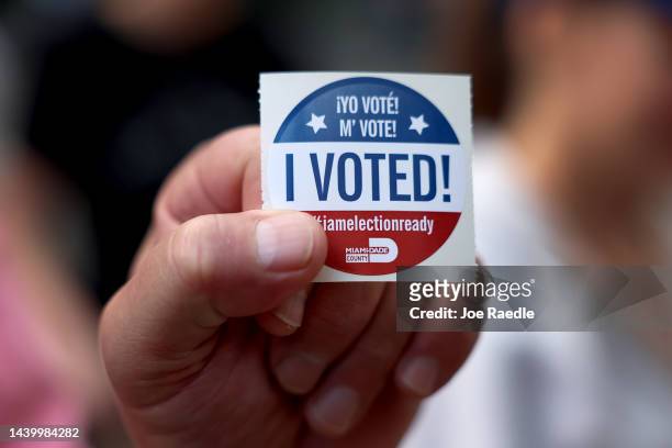 Voter shows off their, 'I Voted", sticker after casting their ballot at a polling station on November 08, 2022 in Miami, Florida. After months of...