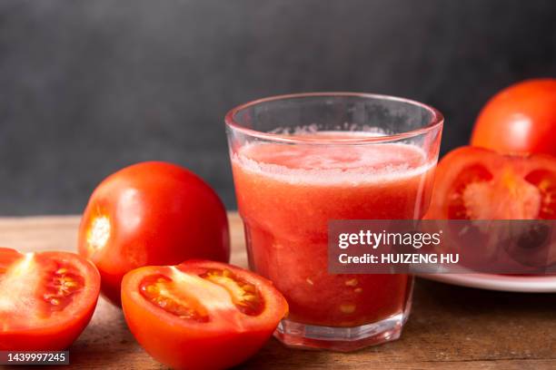 tomato juice with tomatoes on wooden table - tomatensap stockfoto's en -beelden