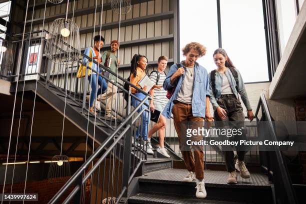 lächelnde college-studenten gehen die treppe hinunter zu ihrer nächsten klasse - on the campus stock-fotos und bilder
