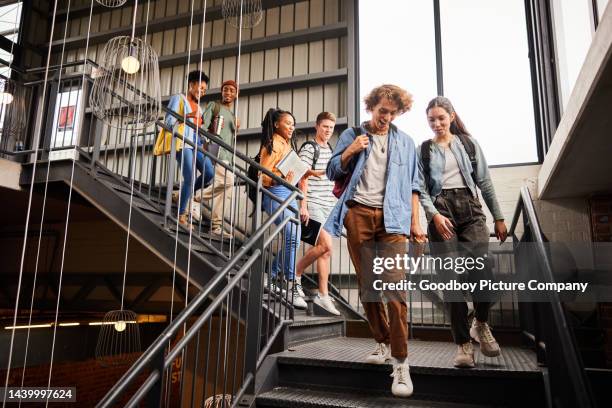 smiling college students walking down stairs to their next class - campus imagens e fotografias de stock