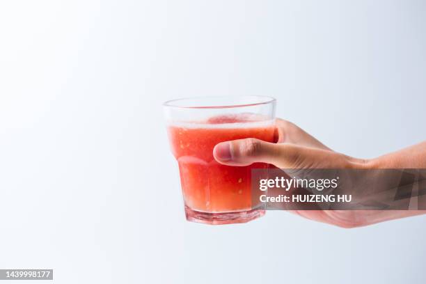 female hand holding glass of tomato juice - tomato juice stock pictures, royalty-free photos & images