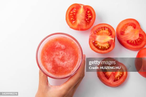 woman holding glass of tomato juice - tomato juice stock pictures, royalty-free photos & images