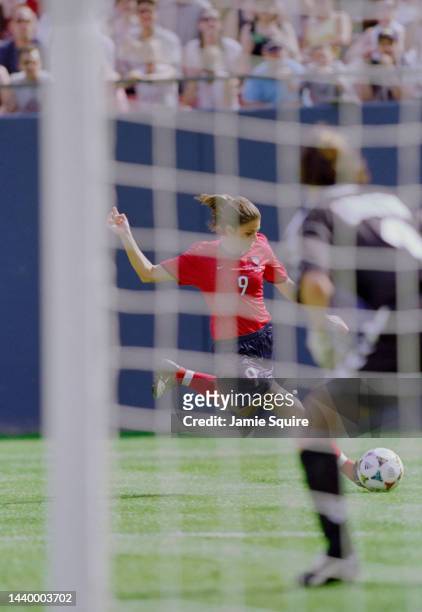 Mia Hamm, Forward for the United States turns to shoot for goal against Dorthe Larsen, Goalkeeper for Denmark during their Group A of the FIFA...
