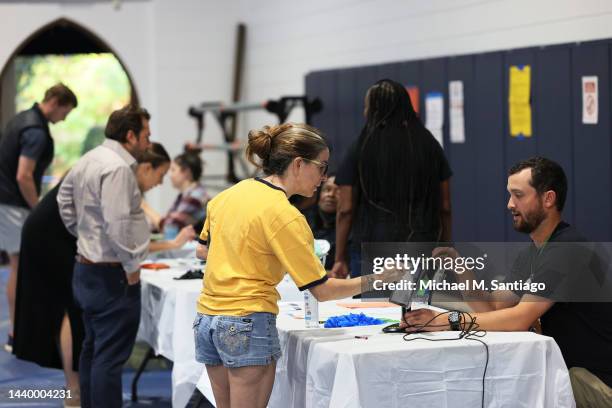 People check in to vote during the Midterm Elections at Morningside Baptist Church Gym on November 08, 2022 in Atlanta, Georgia. After months of...