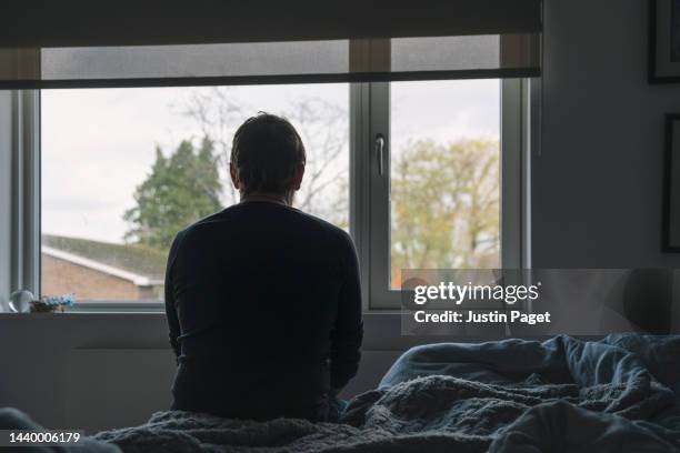 mature male sitting on his bed - negative emotion - bed conflict stock pictures, royalty-free photos & images