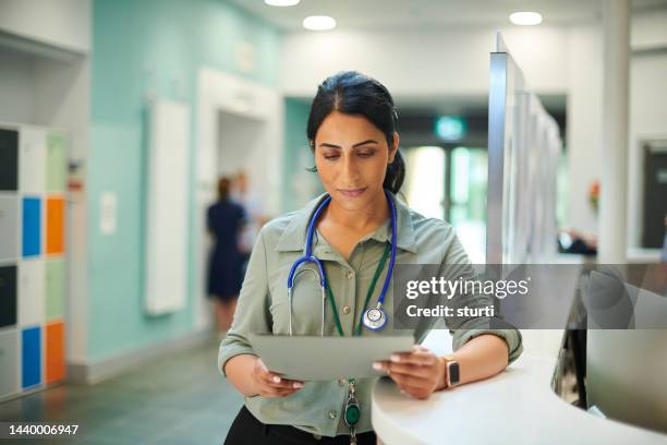 hospital doctor reading medical notes - medisch dossier stockfoto's en -beelden