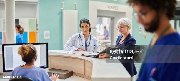 medical team chatting to administrator - recovery room stock pictures, royalty-free photos & images