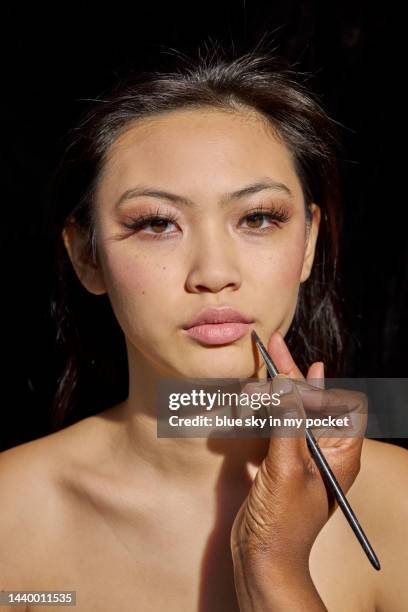 a make-up artist applying lipstick to a model - makeup before and after bildbanksfoton och bilder