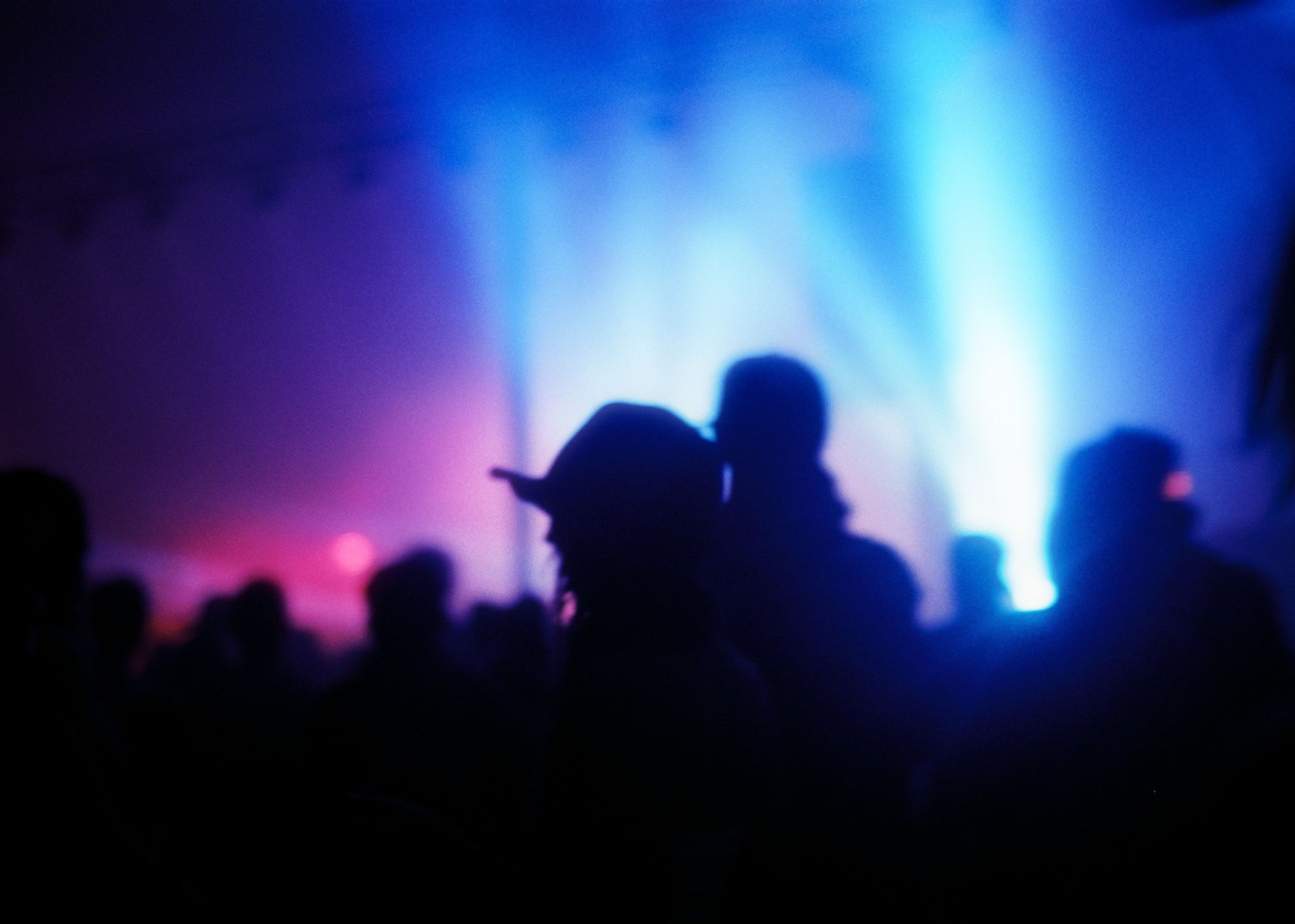 Blurry shot of a lot of people at a concert with spotlights in the background Blurry shot of a lot of people at a concert with spotlights in the background