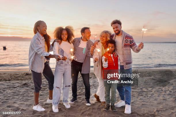 multi-generation family celebrating christmas on the beach - family new year's eve stock pictures, royalty-free photos & images