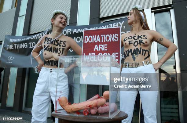 Activists from the feminist group Femen hold giant pairs of scissors calling on men to "donate their penises" as they demonstrate against the roles...