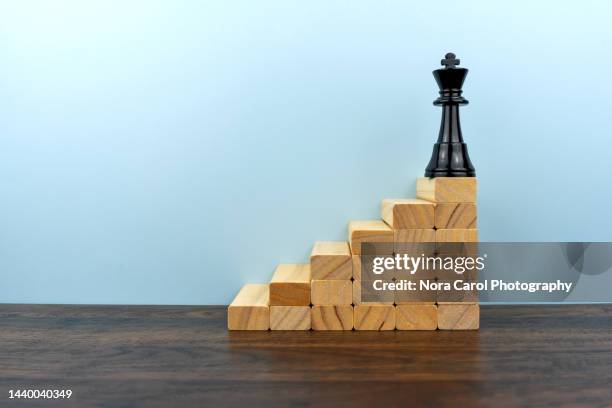 chess king on top of wood block steps - king chess piece stock pictures, royalty-free photos & images