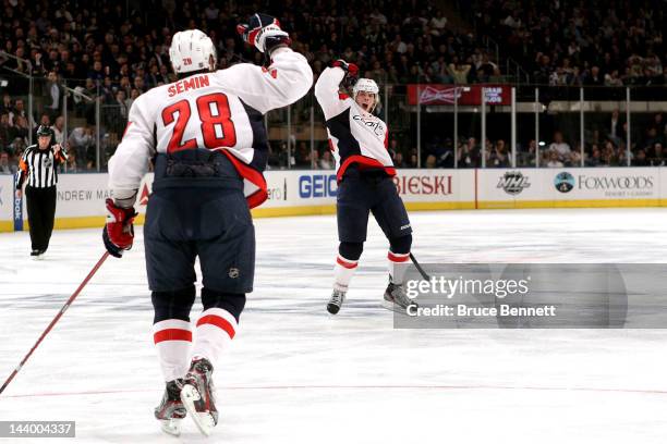 John Carlson of the Washington Capitals celebrates with teammate Alexander Semin after scoring a goal in the third period against Henrik Lundqvist of...