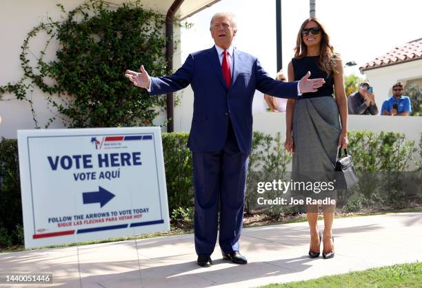 Former U.S. President Donald Trump stands with former first lady Melania Trump as he speaks to the media after voting at a polling station setup in...