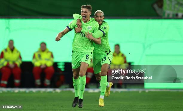 Micky van de Ven of VfL Wolfsburg celebrates with teammate Omar Marmoush after scoring their side's first goal during the Bundesliga match between...