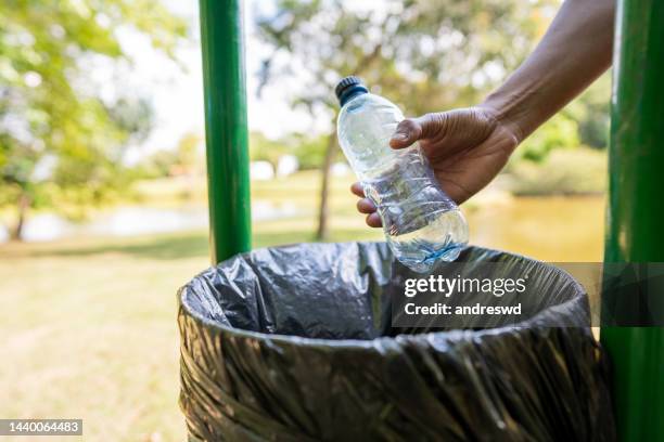 throw a plastic bottle in the recycling bin - recylcebak stockfoto's en -beelden