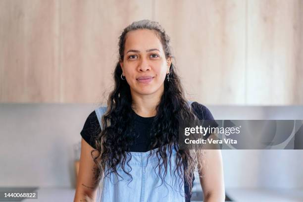 front portrait of latin american woman in casual clothes with curly long hair. - vita domestica fotografías e imágenes de stock