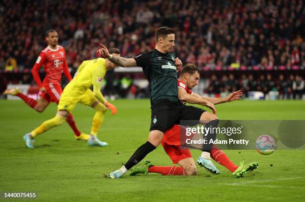 Leon Goretzka of Bayern Munich scores their team's third goal under pressure from Marco Friedl of SV Werder Bremen during the Bundesliga match...