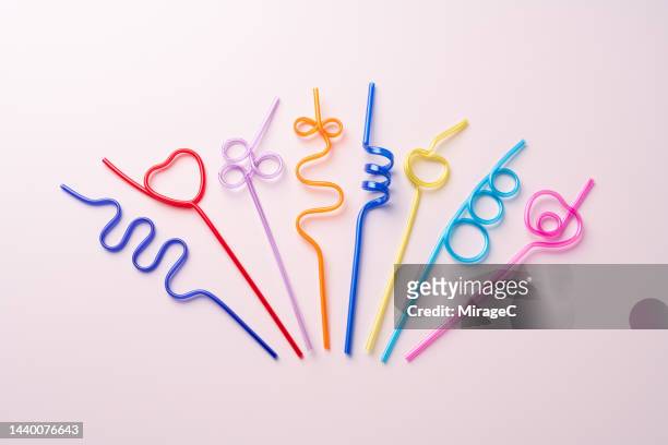 a variety of colorful plastic drinking straws fanned out on pink - drinking straw 個照片及圖片檔