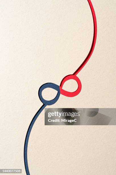 paper cut of a connected infinity symbol with blue and red colors - compatibilità foto e immagini stock