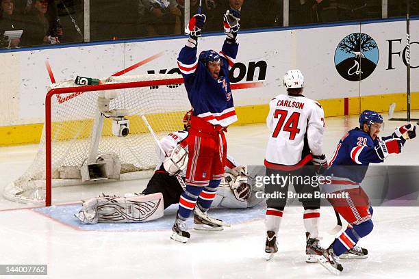 Artem Anisimov and Derek Stepan of the New York Rangers celebrate as teammate Marc Staal , scores the winning goal in overtime against Braden Holtby...