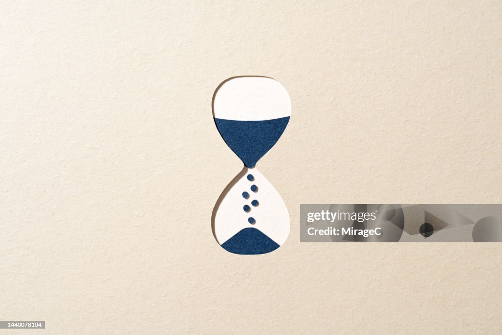 Blue Hourglass Passing Time on Beige Paper Cut Craft