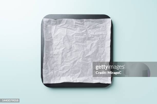 empty baking tray covered with crumpled baking paper - backblech stock-fotos und bilder