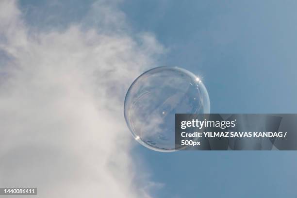 low angle view of bubble against sky - blowing bubbles foto e immagini stock
