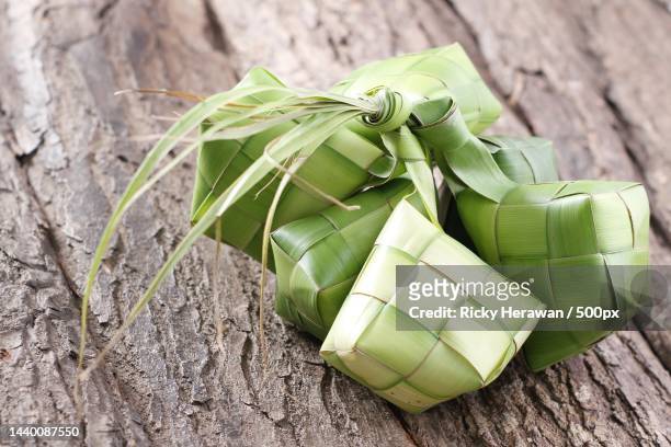 high angle view of ketupat food wrapped in leaves on table,bekasi,indonesia - ketupat stock pictures, royalty-free photos & images