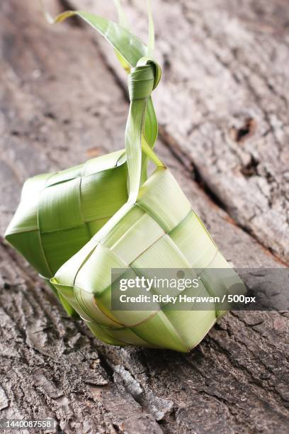 high angle view of ketupat food wrapped in leaves on table - ketupat stock pictures, royalty-free photos & images