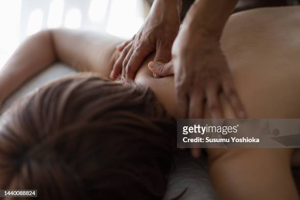 a woman receives an oil massage treatment from an esthetician at a private esthetic salon. - body massage japan stock pictures, royalty-free photos & images