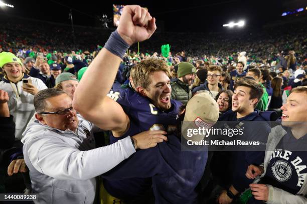 Michael Mayer of the Notre Dame Fighting Irish celebrates with fans who stormed the field after defeating the Clemson Tigers 35-14 at Notre Dame...