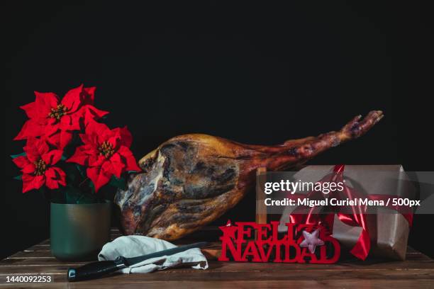 spanish ham with a poinsettia,a gift,a merry christmas sign on a black background with a gift box,valladolid,spain - gifta 個照片及圖片檔