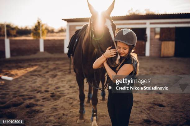ein mädchen umarmt ihr pferd - pferderitt stock-fotos und bilder