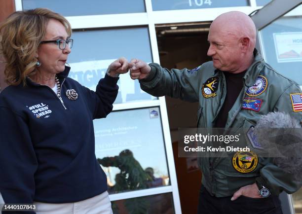Sen. Mark Kelly fist bumps his wife former Rep. Gabby Giffords as they speak to campaign volunteers on Election Day on November 08, 2022 in Tucson,...