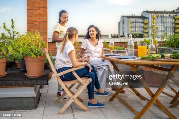 women having a quality time at the rooftop dinner party - rooftop deck stock pictures, royalty-free photos & images