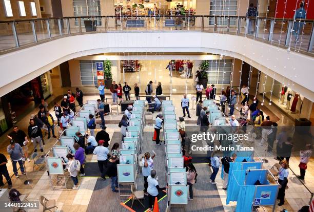 People vote as poll workers assist at a polling place at Galleria at Sunset on November 08, 2022 in Henderson, Nevada. After months of candidates...