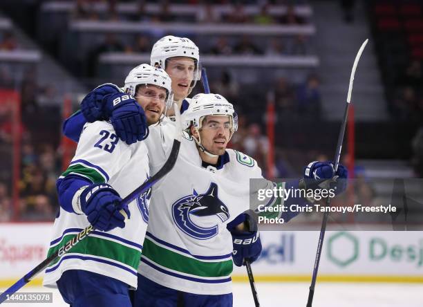 Oliver Ekman-Larsson of the Vancouver Canucks celebrates his third period goal against the Ottawa Senators with Tyler Myers and Conor Garland during...