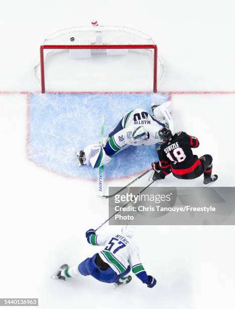 Tim Stützle of the Ottawa Senators scores against Spencer Martin of the Vancouver Canucks as his teammate Tyler Myers looks on in the third period of...