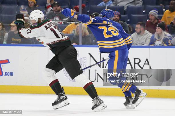 Nick Bjugstad of the Arizona Coyotes tries to pull his stick from Lawrence Pilut of the Buffalo Sabres during the third period of an NHL hockey game...