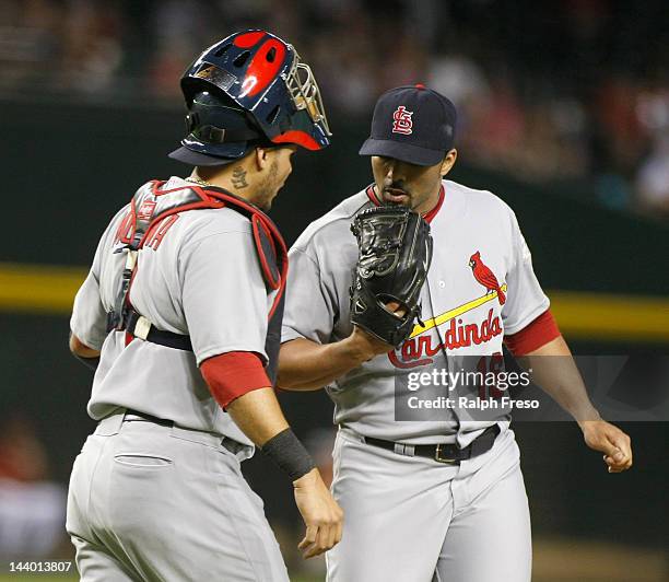 Yadier Molina of the St. Louis Cardinals visits the mound to talk with pitcher J.C. Romero after the Arizona Diamondbacks score four runs during the...