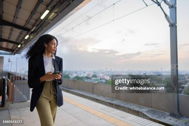 ヘッドフォンで音楽を聴きながら電車を待っている実業家。 - 通勤電車 ストックフォトと画像