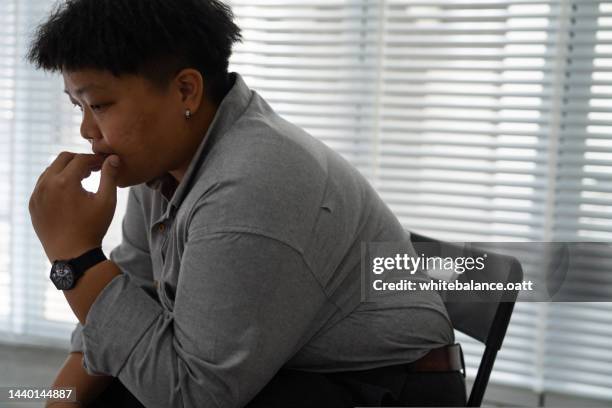 asian man sitting in room alone waiting for group therapy feeling nervous. - obesity imagens e fotografias de stock