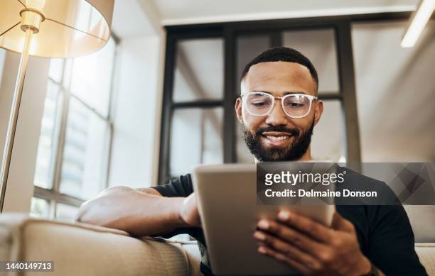 black man, tablet and smile for social media post, shopping online or browsing internet creative content at home. young africa american happy, relax and calm on tech digital app on device - kijken stockfoto's en -beelden